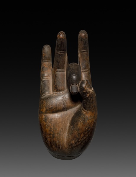 Nara late-700s carved-wood Buddha hand fragment, 40 cm. Palm faces the viewer; three fingers extended, one curved to the thumb — vitarka gesture. Weathered grain.