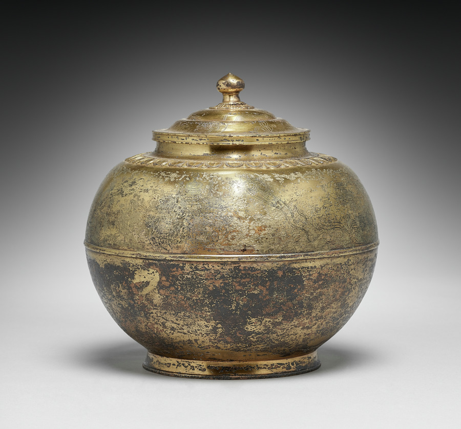 Heian gilt-bronze covered cinerary urn, 800s–900s, 26 cm. Pomegranate-bud finial on a stepped lid; chased petal-band; faint Pure Land engraving above.
