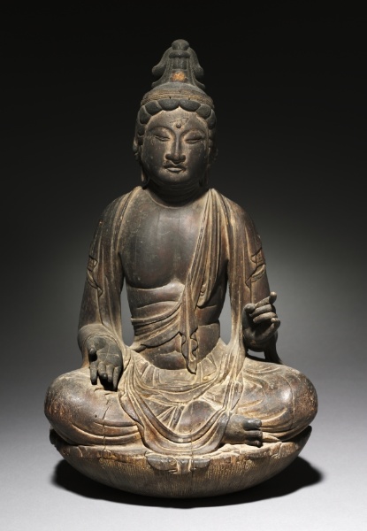 Heian c. 800 seated Nikkō Bosatsu in kaya wood, 47 cm. Single-block, weathered surface. Proper-left hand raised at chest for the now-lost sun-disc attribute.