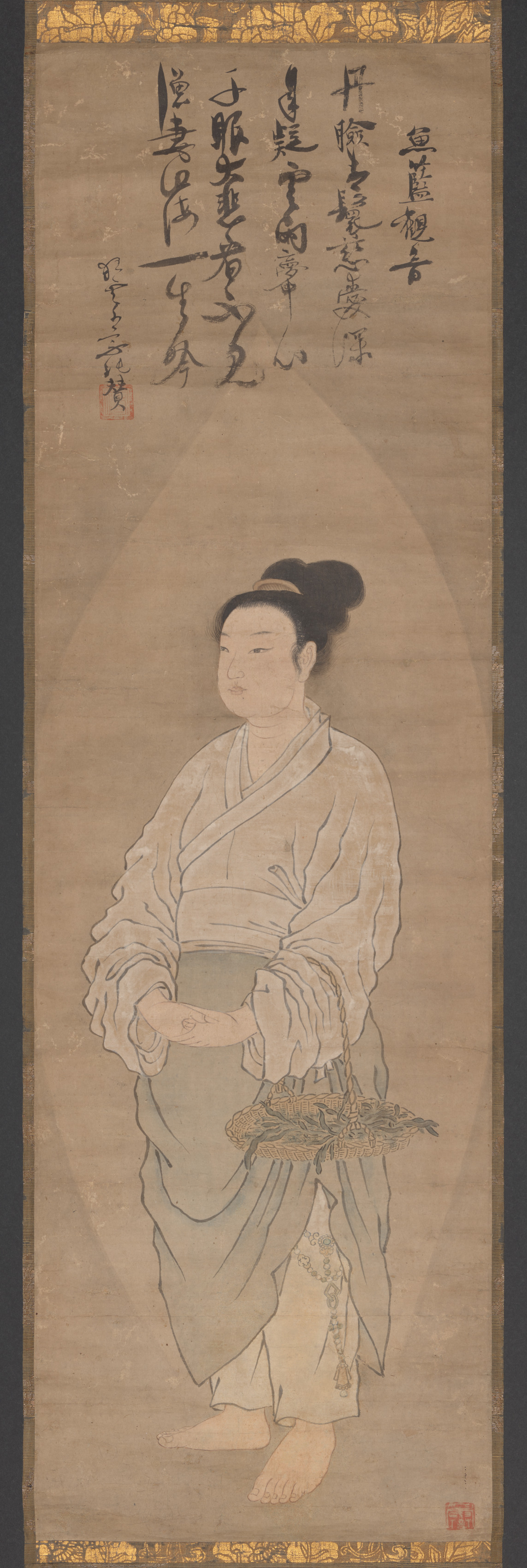 Tall hanging scroll: a barefoot woman in cream robes stands within an almond-shaped mandorla, holding a woven basket with greenery and small fish; Japanese calligraphy and red