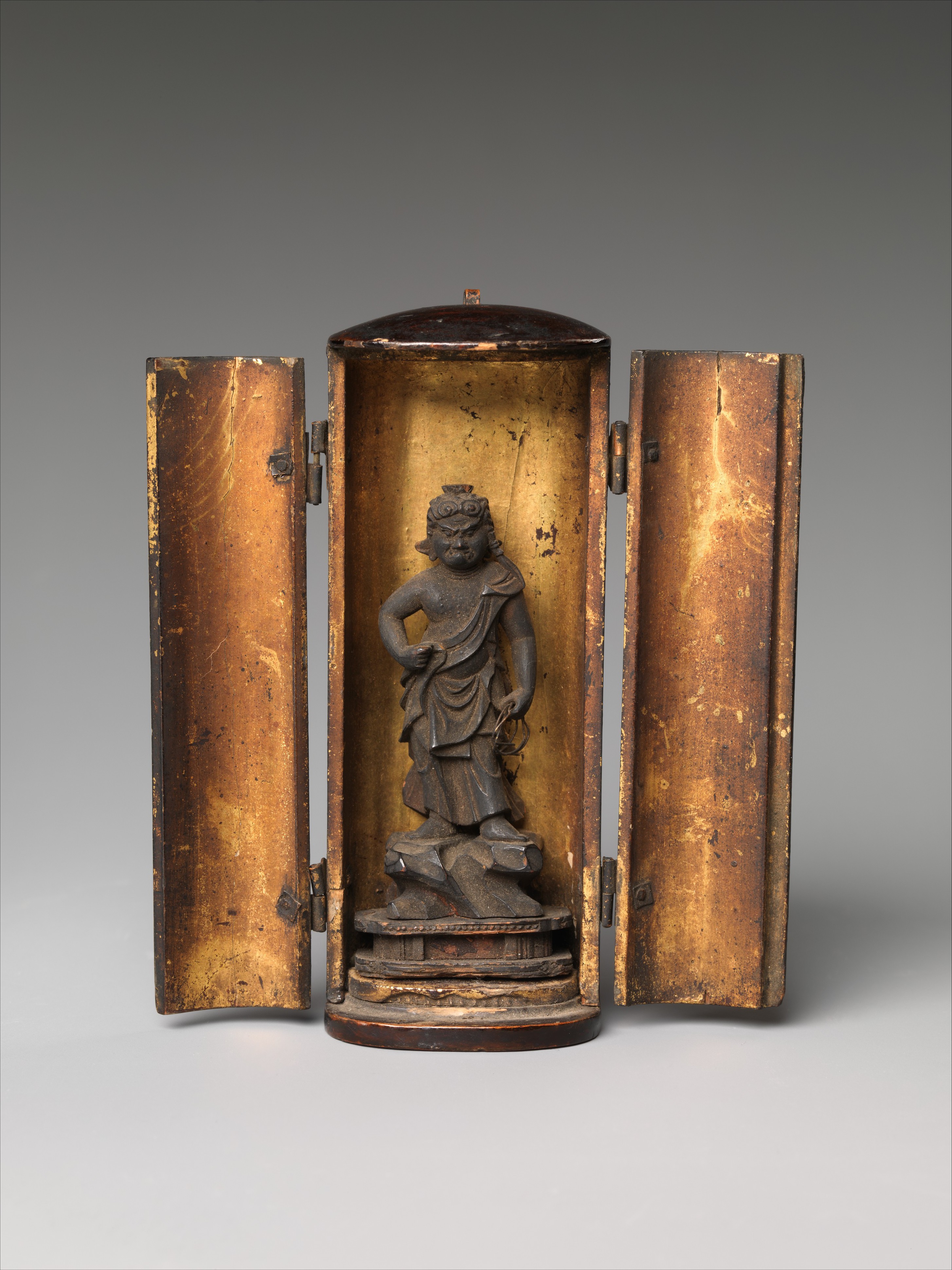 Open miniature lacquer shrine, gold interior, holding a standing Fudō Myōō under four centimeters tall — sword raised, lasso in the left hand, against a carved flame mandorla.