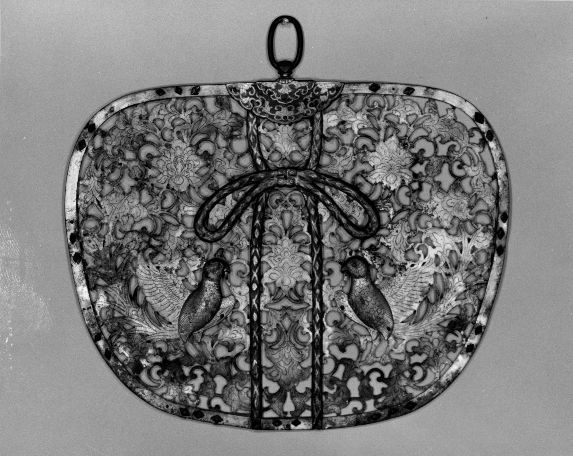 Fan-shaped gilt-bronze pendant pierced into a lacework field of curling flower-scroll, with paired birds in the openwork and a knotted cord-and-tassel along the lower edge.