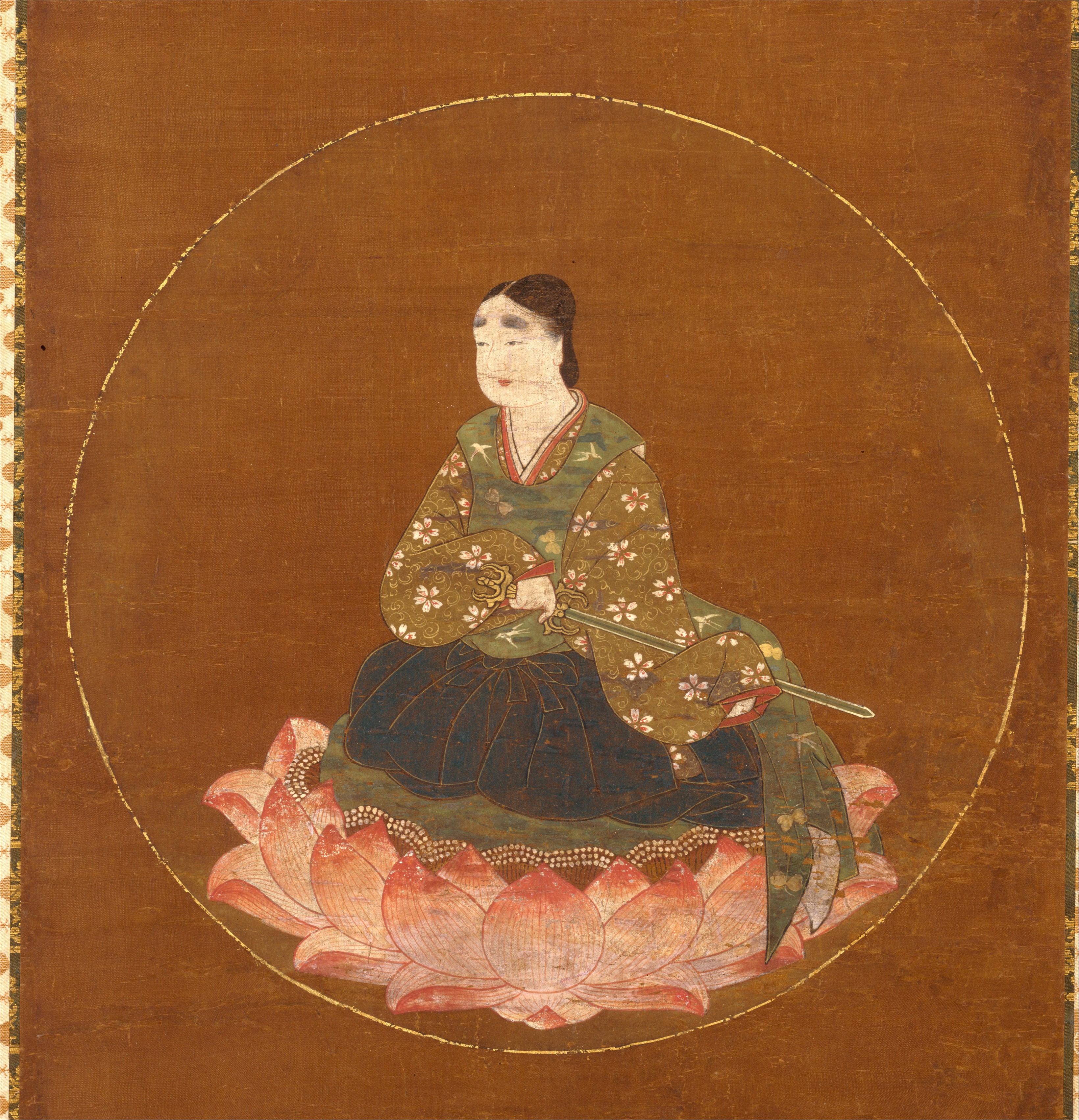 Hanging scroll, ink colour gold and cut gold on silk, 75.6 × 38.1 cm. A youthful courtly figure in white robes sits on a lotus within a gold disc above a shrine compound at a