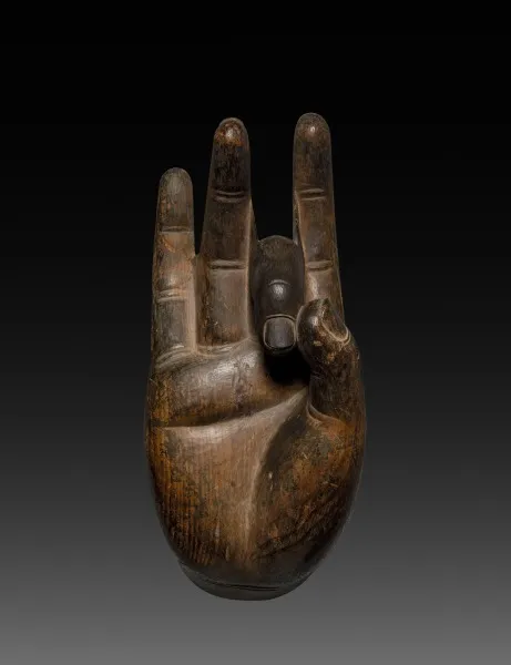 Nara late-700s carved-wood Buddha hand fragment, 40 cm. Palm faces the viewer; three fingers extended, one curved to the thumb — vitarka gesture. Weathered grain.