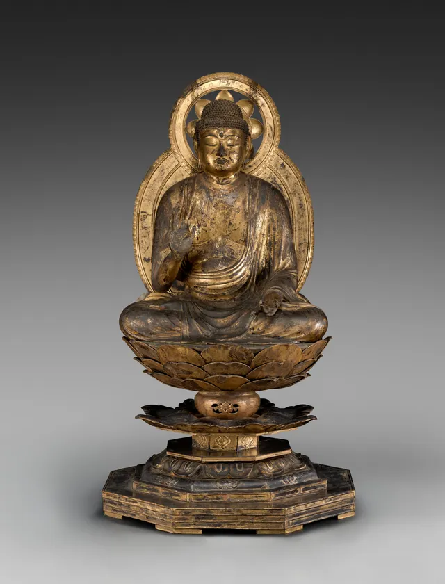 Late-Heian seated Buddha in gilded yosegi wood, 1100s, 145 cm on a lotus pedestal. Right hand in abhaya mudrā; left hand a later replacement, gesture lost.