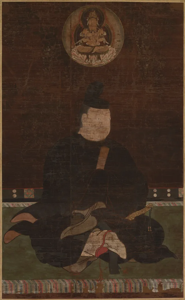 Hanging scroll, ink colour gold and cut gold on silk, 141 cm tall. A robed seated nobleman in formal court dress faces forward; a small gold-ground roundel containing a crowned