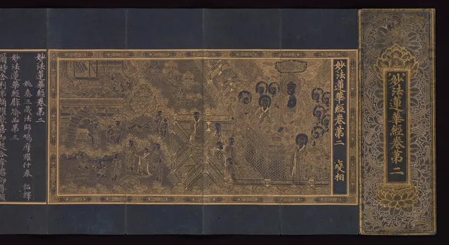 An opened Goryeo accordion-fold sutra book on a dark indigo ground. A gold-line frontispiece painting fills the centre: the Buddha enthroned at the right under a jeweled canopy