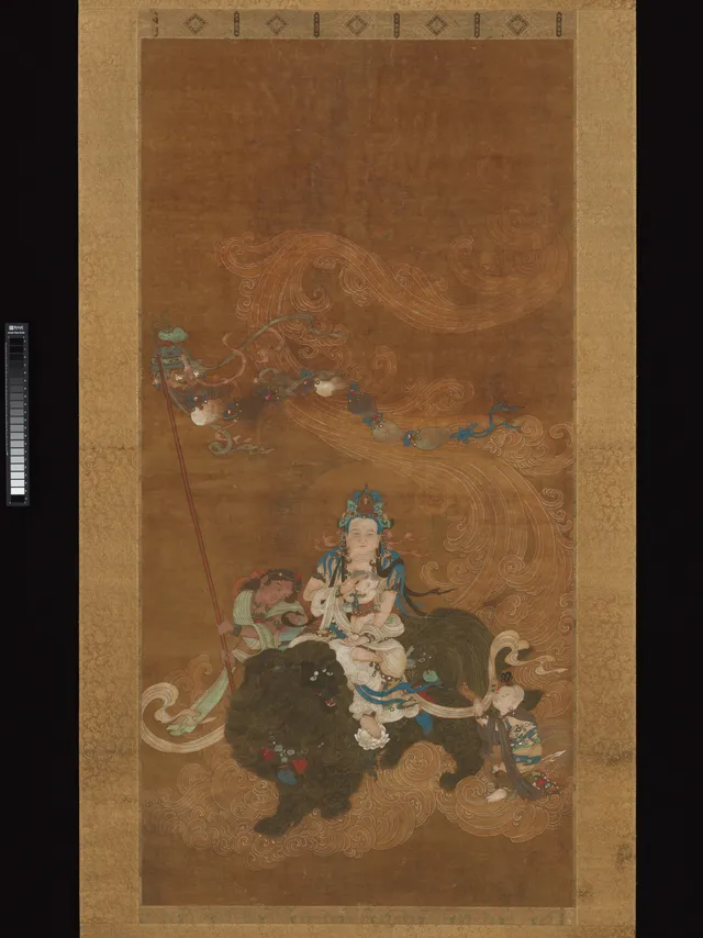 Ming hanging scroll, ink colour and gold on silk, 121 × 60 cm. White-robed Guanyin seated on a lion descending on a cloud, holding a robed male infant, a small kneeling boy below.
