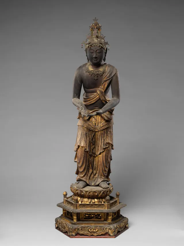 Kamakura attendant Kannon in painted-and-gilt wood with gyokugan eyes, late 12th–13th c., 84 cm. Raigō contrapposto; lotus stem at left hand; tall crown.